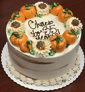 Cake decorated with pumpkins and the words "Cheers to 35 years!"