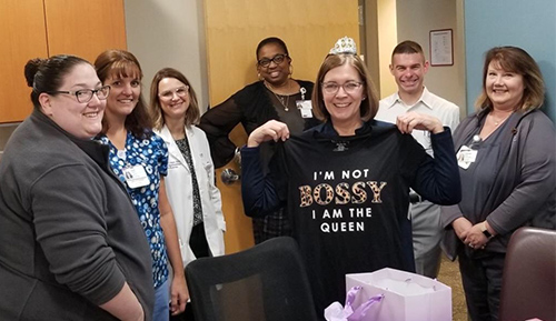 The clinic staff give Laura Peduzzi a gift - a shirt that says "I'm not bossy, I'm the queen"